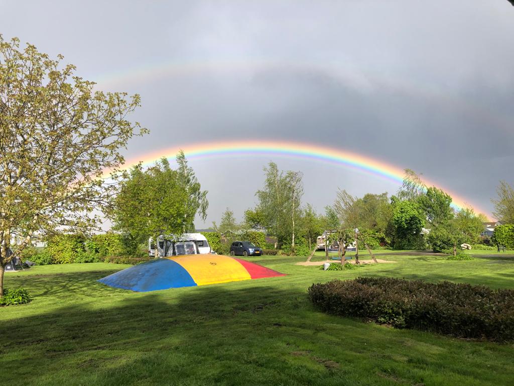 regenboog met air trampoline op boerencamping met speelveldje